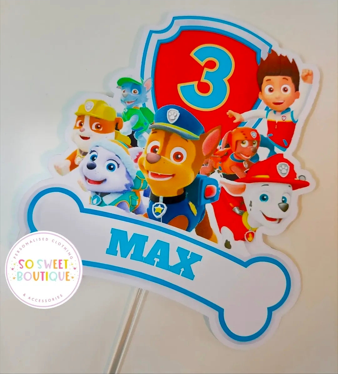 Blue Paw Patrol birthday cake topper personalized with name, featuring cartoon pups, from SoSweetBoutiqueLtd.